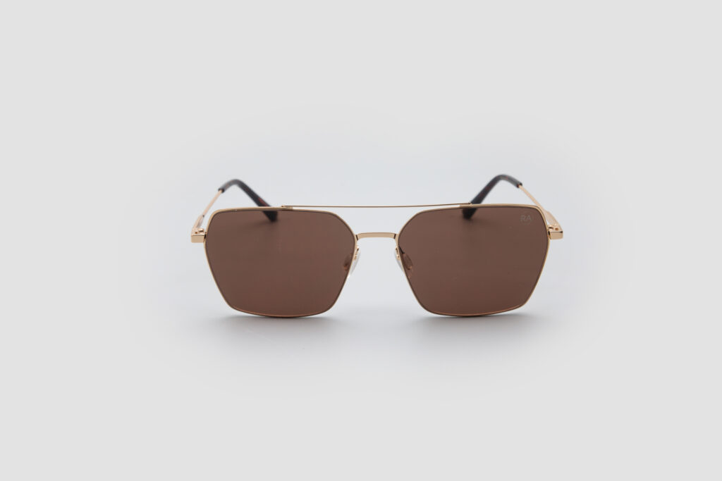 A pair of brown-tinted, square-framed aviator sunglasses with a gold-tone metal frame against a white background.